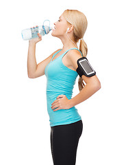 Image showing sporty woman running with smartphone and earphones