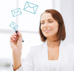 Image showing businesswoman drawing envelopes in the air