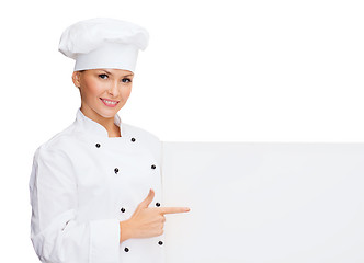 Image showing smiling female chef with white blank board