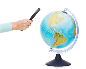 Image showing woman hand holding magnifying glass over globe