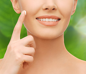 Image showing closeup of woman hand applying moisturizing cream