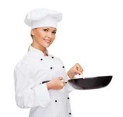 Image showing smiling female chef with pan and spoon