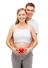 Image showing happy young family expecting child with heart