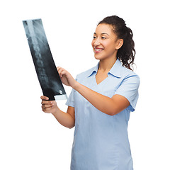 Image showing smiling female doctor or nurse looking at x-ray