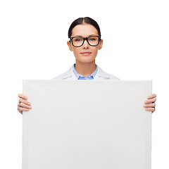 Image showing female doctor in eyeglasses with white blank board