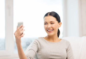 Image showing smiling woman with smartphone at home