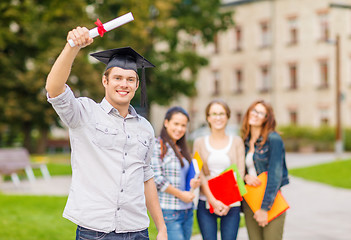 Image showing smiling teenage boy in corner-cap with diploma