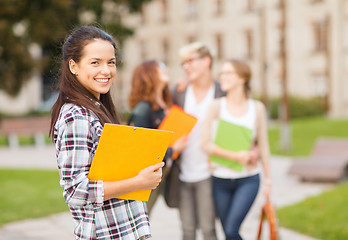 Image showing teenage girl with folders and mates on the back