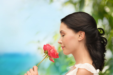 Image showing smiling woman smelling flower