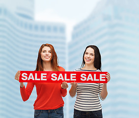 Image showing two smiling teenage girl with percent sign on box