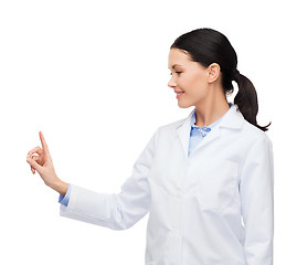Image showing smiling female doctor pointing to something