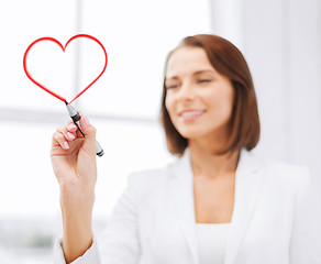 Image showing businesswoman drawing heart in the air