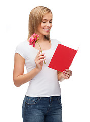 Image showing smiling girl with postcard and flower