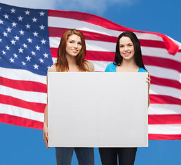 Image showing two smiling young girls with blank white board