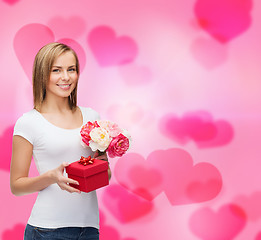 Image showing smiling woman with bouquet of flowers and gift box