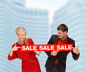 Image showing smiling woman and man with red sale sign