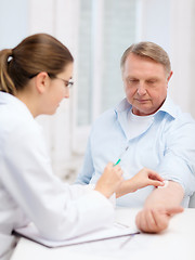 Image showing female doctor doing injection to old man