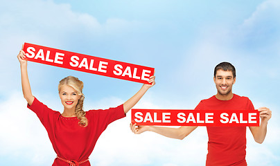 Image showing smiling woman and man with red sale signs