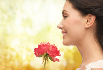 Image showing smiling woman smelling flower