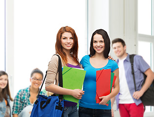 Image showing two smiling students with bag and folders