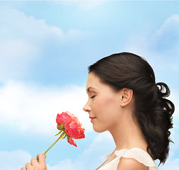 Image showing smiling woman smelling flower