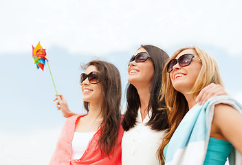 Image showing smiling girls in shades having fun on the beach