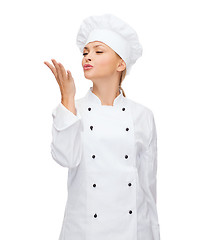 Image showing smiling female chef showing delicious sign