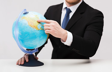 Image showing businessman pointing finger to earth globe