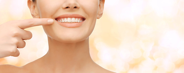 Image showing beautiful woman pointing to teeth