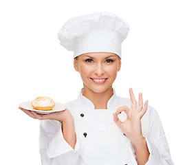 Image showing smiling female chef with cake on plate