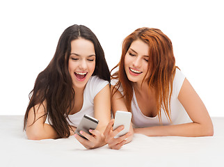 Image showing two smiling teenagers with smartphones