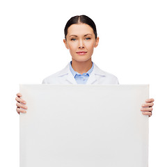 Image showing calm female doctor with white blank board