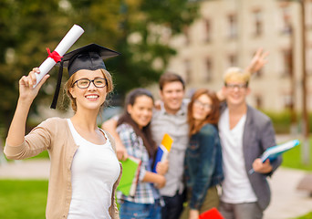 Image showing smiling teenage girl in corner-cap with diploma