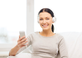 Image showing woman with smartphone and headphones at home