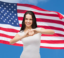 Image showing smiling girl showing heart with hands