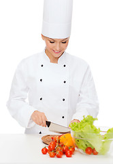 Image showing smiling female chef chopping vagetables