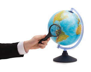 Image showing businessman hand holding magnifier over globe