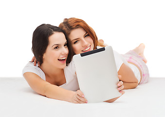 Image showing two smiling teenage girls with tablet computer