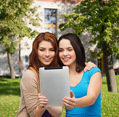 Image showing two smiling teenagers with tablet pc computer