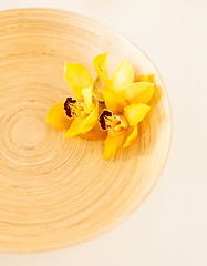 Image showing closeup of wooden bowl with orchid flowers