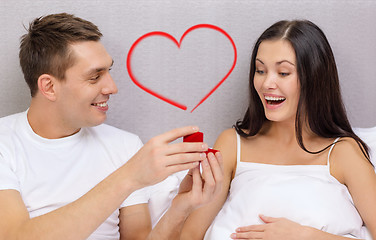 Image showing man giving woman little red box and ring in it