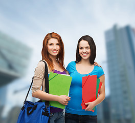 Image showing two smiling students with bag and folders