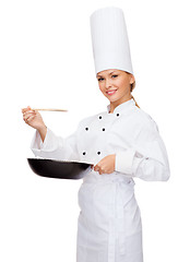 Image showing smiling female chef with pan and spoon