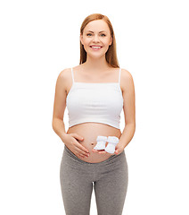 Image showing happy future mother holding bootees