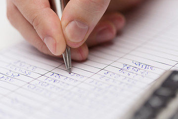 Image showing close up of businessman with papers and calculator