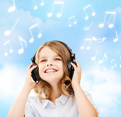 Image showing smiling little girl with headphones at home