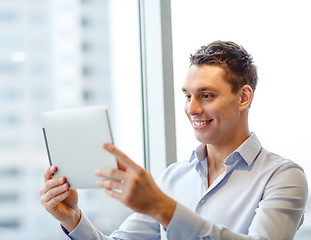 Image showing smiling businessman with tablet pc in office