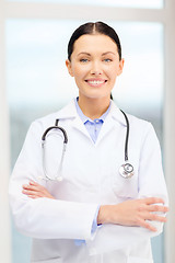 Image showing smiling young doctor with stethoscope in cabinet