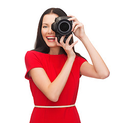 Image showing smiling woman taking picture with digital camera