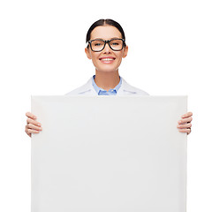 Image showing female doctor in eyeglasses with white blank board